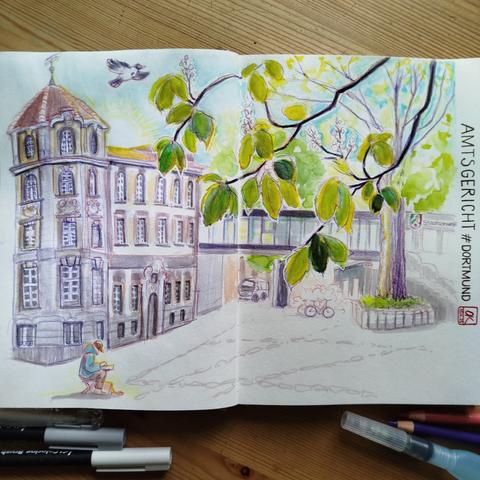 Doppelseite im Skizzenbuch mit Blick auf den historischen Bau des Amtsgerichts, den modernen gläsernen Verbindungstunnel zur Staatsanwaltschaft, Kastanienbaumzweige und einen zeichnenden Sketcher.

Double page in the sketchbook with a view of the historic building of the district court, the modern glass connecting tunnel to the public prosecutor's office, chestnut tree branches and a sketcher drawing.