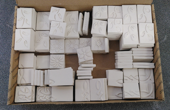 Ceramic mosaic tiles all organized in a box. Bisqueware ready to be glaze. Flowers, leaves, Celtic designs...