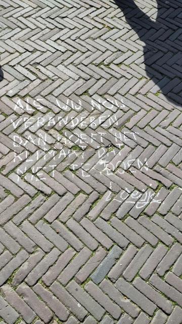 Chalk text in Dutch: "Als wij nou veranderen dan hoeft het klimaat dat niet te doen"