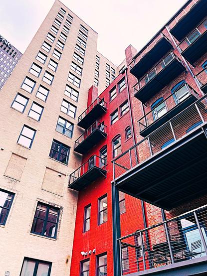 Color image, Bowery District Buildings, located along the Ohio & Erie Canal and Towpath, Akron, Summit County, Ohio, USA. Image shows buildings in the Bowery District ranging between 1880 - 1970, most now residential apartments and condominiums. Image shows a gray sky over buildings of 25 stories, 11 stories, and 6 stories, in steel and glass, buff brick and terra cotta, and red brick and ironwork.