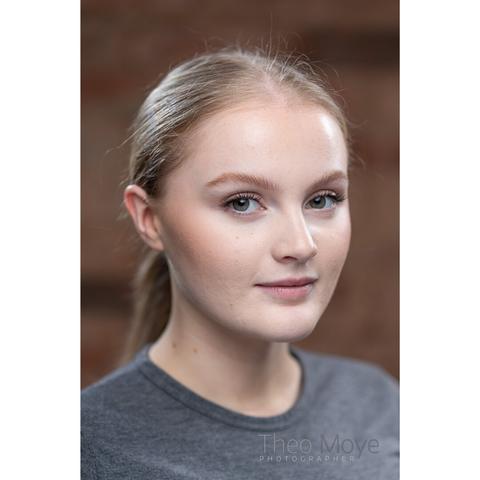 A young woman with her blonde hair tied back