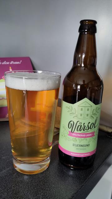 Öl i glas med flaska bredvid.