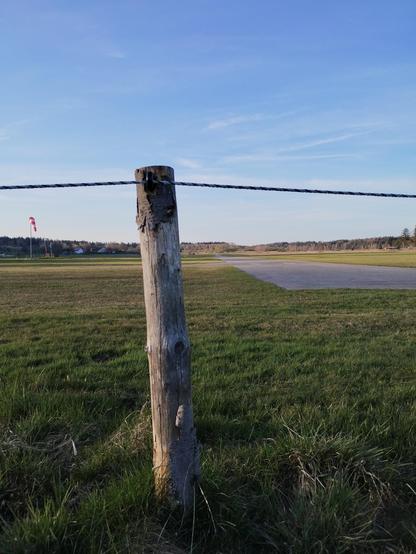 Pole supporting a wire crossing right in front of runway threshhold