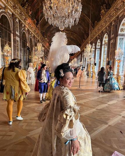 Christine wears a gold-toned brocade robe a la francaise at the Palace of Versailles.