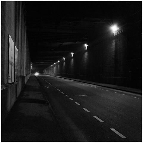 The scenery looks like a tunnel but technically its a series of many bridges. The headlines of a car are at the end of the construction.