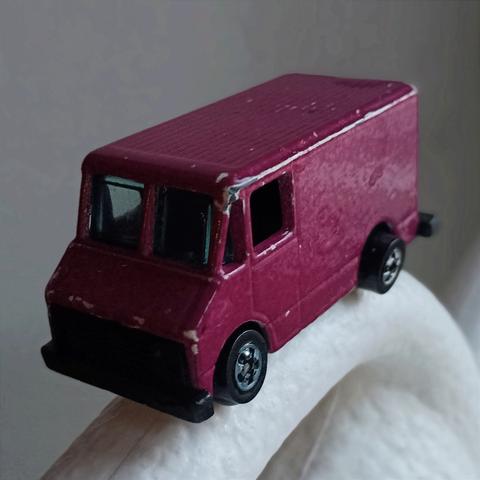 Pieni lelupakettiauto, jossa tuulilasina kovaa muovia ja sivuikkunoiden paikalla aukot ilman lasia.Kulmissa kolhuja ja toinen eturengas vähän vinksallaan.