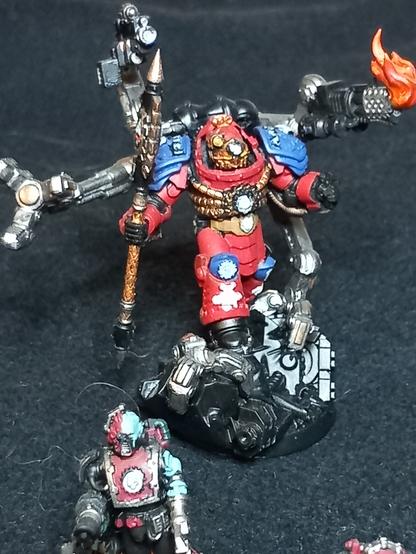 Ein Primaris-Techmarine aus dem 3D-Drucker, farblich den Ultramarines zugehörig, weitestgehend in klassischem rot gehalten.
