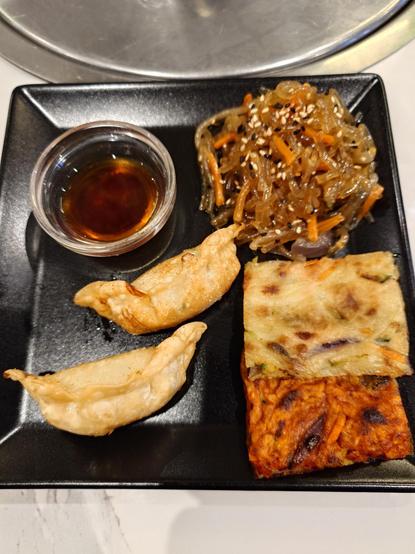Korean starter dish
2 squared pieces of Korean pancakes (one red with kimchi)
A tasting of japchae noodles 
2 pieces of steamed ravioli and their sauce