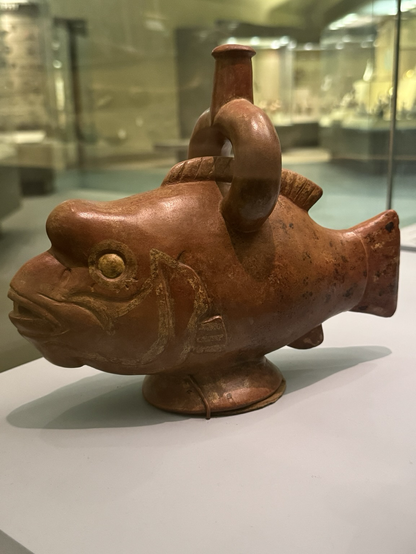 photo of the first parrotfish ceramic vessel on display at museum: single ring spout on top, red-brown with molded and incised details, including distinctive hump on head
