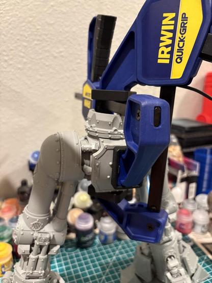 The back top of the pelvis and thighs of a reaver Titan. Two clamps are holding the rear pelvis armor in place while the glue sets. Under the armor you can just barely see the hip pistons that were cut and put in place.