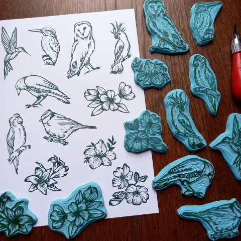 Série de tampons gravés à la main, un corbeau, une mésange, un cacatoes, une chouette, un perroquet, un colibri, un marrin pêcheur, et des motifs fleuris.