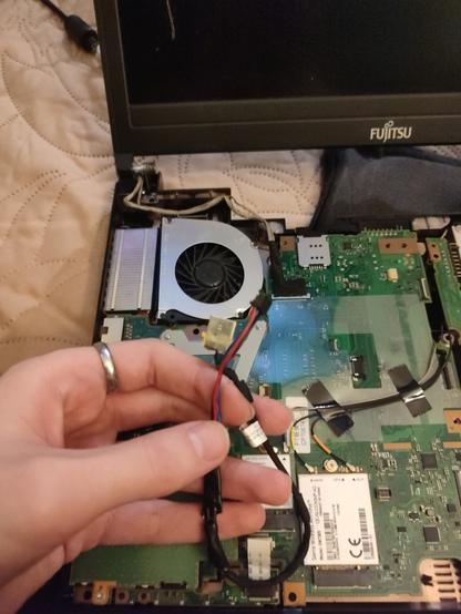 picture showing a disassembled laptop and a power cord