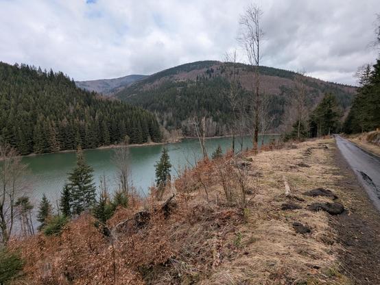 A photo of a lake and surrounding mountains. Cloudy weather.