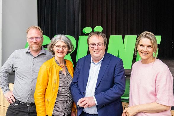 Fotografie von vier Personen vor einem grünen Schriftzug der Grünen.
Vlnr: Daniel Buncic; Stellvertretender Fraktionsvorsitzender der bruehler Grünen, Simone Holderried; Fraktionsvorsitzende und Bürgermeisterkandidatin der brühler Grünen, Oliver Krischer; Minister für Umwelt, Natuschutz und Verkehr in NRW sowie Lisi Kühl, Vorstandssprecherin der brühler Grünen