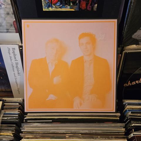 Album cover features pinkish-orange tinted photograph of the musicians.