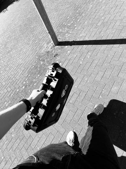 Black hard shell case. All packed up on the way to the tram.