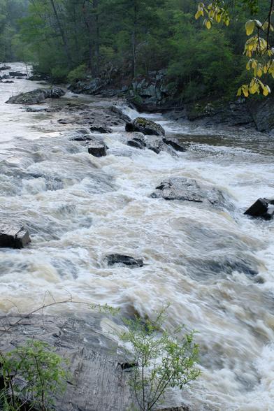 Another view of a lot of water running over rocks down a creek
