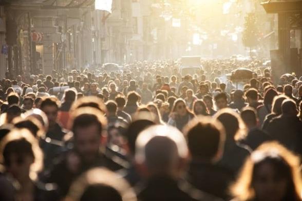 a crowd of thousands of ordinary people filling an ordinary city street.