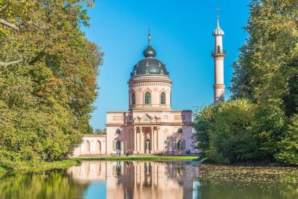 Blick über einen See im Schwetzinger Schlossgarten auf die Moschee, die sich im Wasser spiegelt