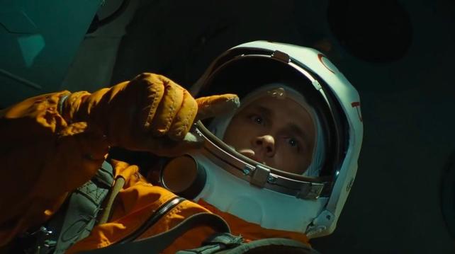 A cosmonaut touches a blob of water floating in zero gravity.