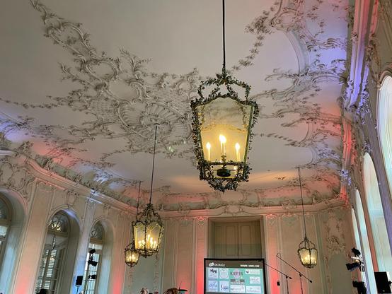 Foto der Stuckdecke mit den riesigen Lampen an der Decke des Mozart-Saals