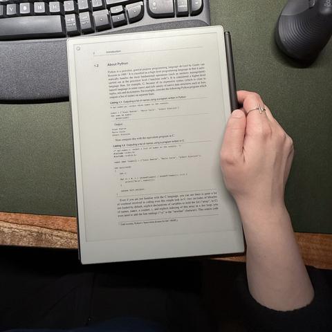 Hand holding a tablet with a textbook in it