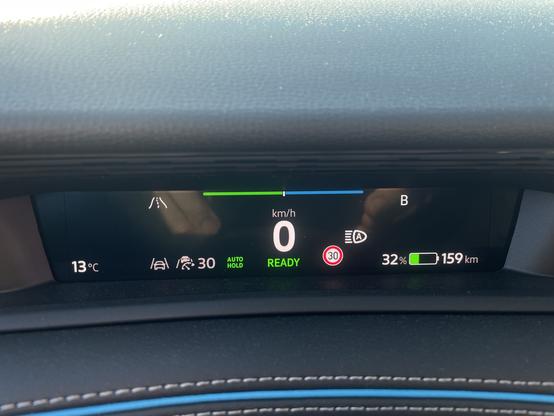 An interior car display showing the following: outside temperature at 13°C, speedometer reading 0 km/h, battery charge at 32%, estimated range of 159 km, and a speed limit indicator of 30 km/h.