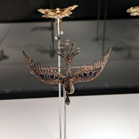 Brooch of a bird flying downwards made of precious metals and gemstones.