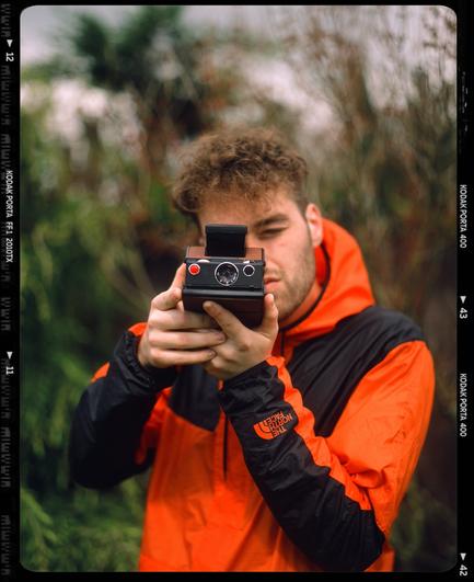 Medium Format photo of my boy shooting a Polaroid SX-70