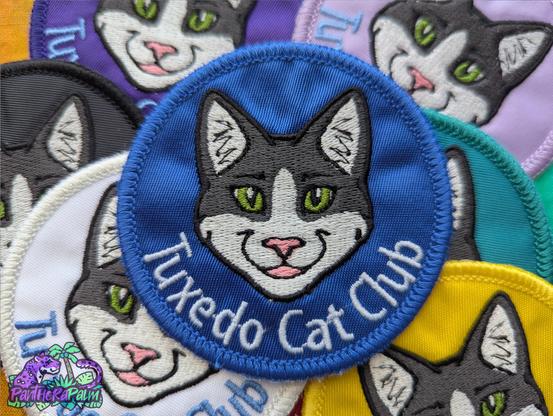 Round patches of various colors with tuxedo cat face and 'Tuxedo Cat Club' text
