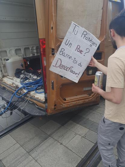 Pancarte à l'arrière d'un camion de la Manifestive de Besançon où il est écrit "Tu protèges un porc ? barre toi du dancefloor"