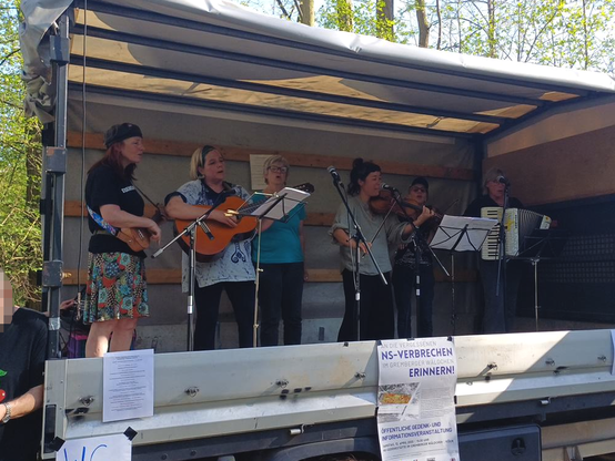 Der "Chor für alle" singt zu Instrumentenbegleitung Widerstandslieder auf der Bühne vom LKW im Grember Wäldchen