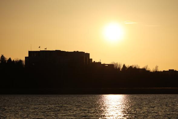 A photo of the setting sun and and a large building.