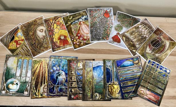 Photograph of several illustrated greeting cards splayed out on a wood surface.