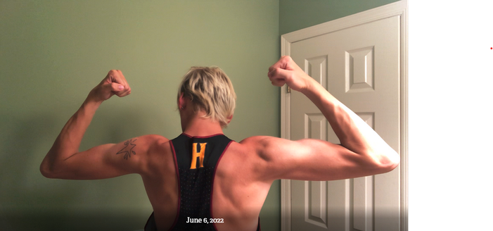 A person who was born male showing their muscles before their transition to female. They have very defined muscles.