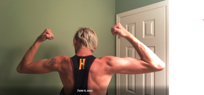 A person who was born male showing their muscles before their transition to female. They have very defined muscles.