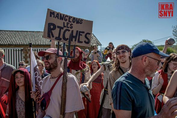 Des mainfestants, une pancarte: "MANGEONS LES RICHES".