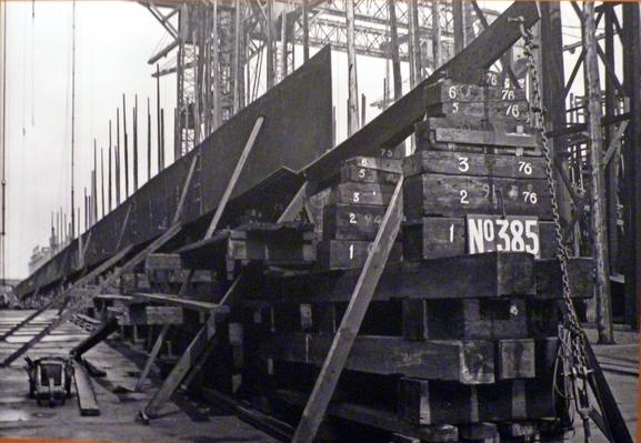 black and white photo showing the laying of the ship's keel, in dry dock, Belfast.