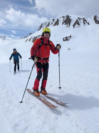 Me on the snow with a valley and peaks in the back.