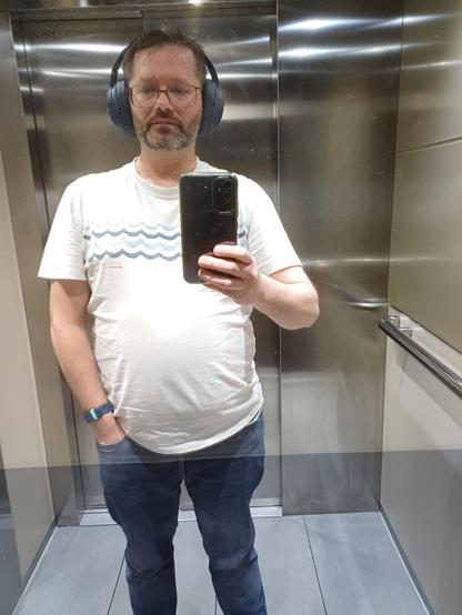 Nothing exciting. Just me in a white tshirt and blue jeans, headphones on, one hand in my pocket and the other holding a peace sign... wait, no, holding a phone. The rest is a lift.

If you liked this caption, please DM me thanking Alanis for her inspiration.