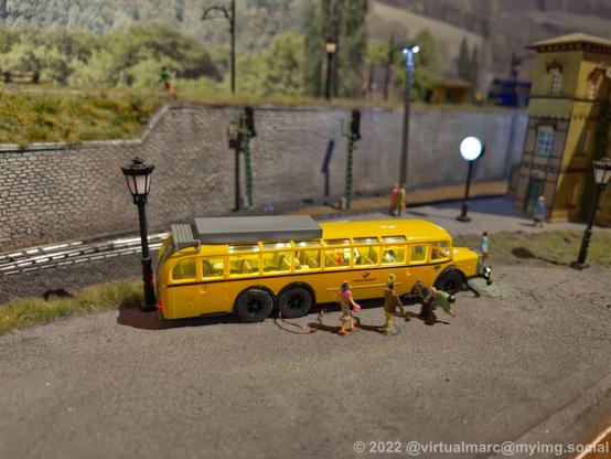 A photo of a post bus with passengers on a model railway.