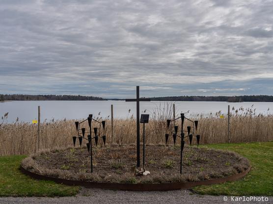 A cross with a lake in the background.