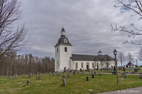 A white church with a cemetery.