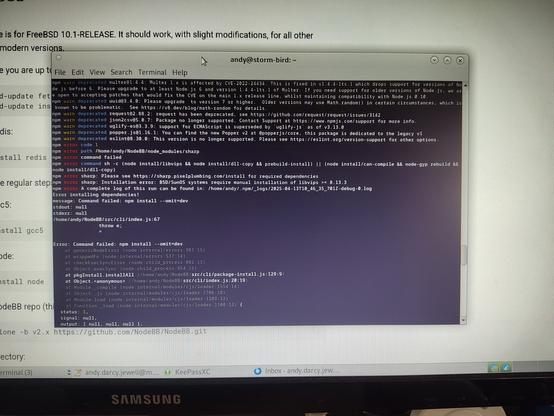 A photo of a Linux terminal emulator screen with multicoloured mono space text on a black background, showing an npm  exception error.