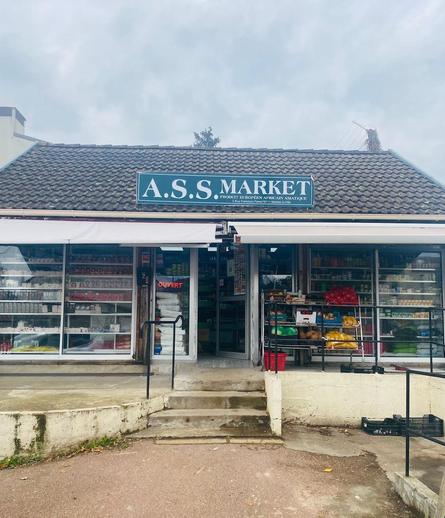 A grocery store. The panel on the roof says « A.S.S. MARKET ».