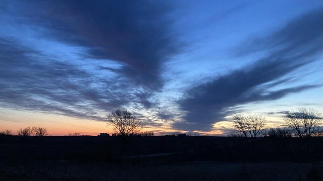 Sunrise on April 6.  A very bold pattern of dark blue and light blue clouds above a narrow strip of pastel orange on the eastern horizon.