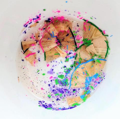 Abfall vom Anspitzen von Buntstiften in den Farben grün, blau, pink und violett