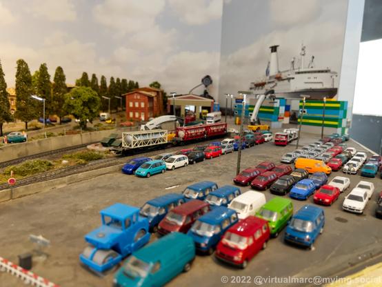 A photo of a big port with many cars and containers on a model railway.