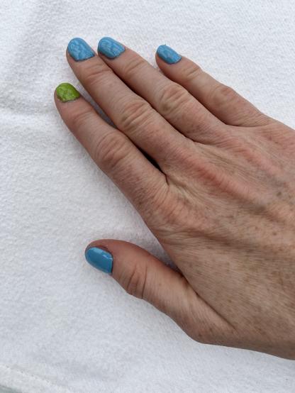 Hand mit blauen und grünen Fingernägeln