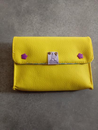 Une pochette jaune citron avec ses pression violette et une étiquette mauve handmade